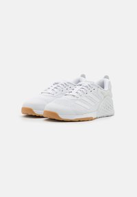 Witte sportschoenen van luchtig materiaal, met een gestructureerde rubberen zool en tonale accenten. Beschikt over een gevoerde kraag en een drie-strepenlogo.