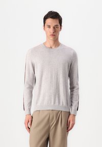 Pull en maille gris avec des manches longues, col rond et rayures latérales contrastantes en orange et bleu marine. Texture douce, coupe décontractée.