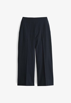 Wijdvallende broek gemaakt van een gestructureerde marineblauwe stof met een gladde tailleband, voorzien van twee zijzakken en een onafgewerkte onderrand.