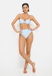 Lyseblå bikinitop med polstret bh og tynne stropper, samt høy midje-bikiniunderdeler. Glatt tekstur, minimalistisk design og uten mønstre.