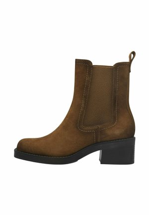 Stivale alla caviglia in suede marrone con pannelli laterali elasticizzati, punta arrotondata e tacco a blocco. Presenta un'etichetta per una facile vestibilità.