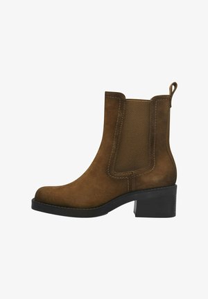 Brown suede ankle boot with elastic side panels, rounded toe, and a block heel. Features a pull tab for easy wear.