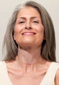 Patch en silicone clair porté sur un individu à la peau claire, mettant en évidence un design lisse et flexible avec un léger éclat contre la peau.