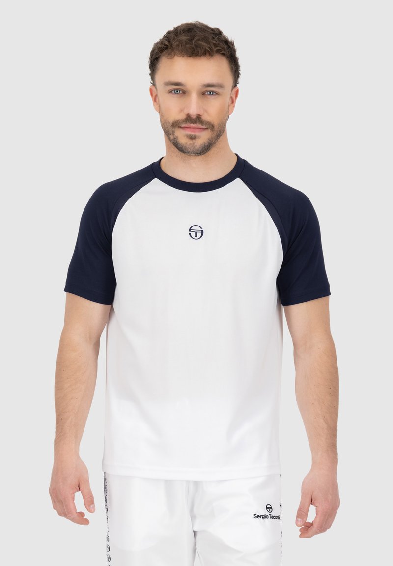 Witte t-shirt met korte mouwen en marineblauwe raglanmouwen, voorzien van een klein logo op de borst. Lichtgewicht stof met een gladde textuur.