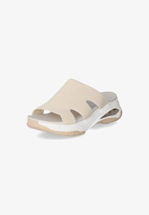 Beige slip-on sandal with a mesh upper, open design, and white sole. Features cut-out sections and textured surface for breathability.