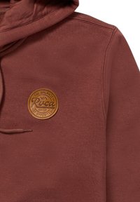 Maroon hoodie featuring a textured fabric, adjustable drawstring, and a circular brown leather patch logo on the front.