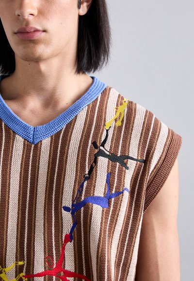 Top senza maniche a maglia con scollatura a V, caratterizzato da righe verticali marroni e crema, decorato con figure ricamate colorate in blu, giallo, rosso e nero.