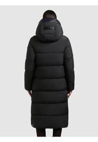 Sort pufferjakke med en aftagelig hætte, der har et quiltet design, sidelommer med lynlås og et brandmærke på bagsiden.