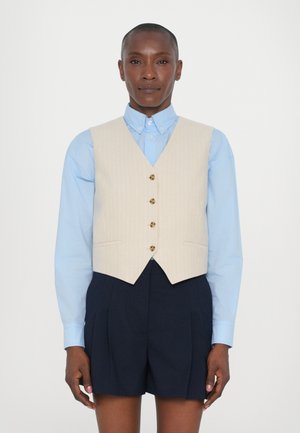 Beige pinstripe liivi, jossa on viisi ruskeaa nappia, käytetään vaaleansinisellä kauluspaidalla ja paritetaan tummansiniharmaiden shortsien kanssa. Sileä kangastekstuuri.