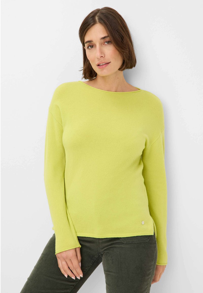 Limettengrüner Strickpullover mit langen Ärmeln, weitem Halsausschnitt und seitlichen Schlitzen, mit einem kleinen silbernen Logo am Saum.