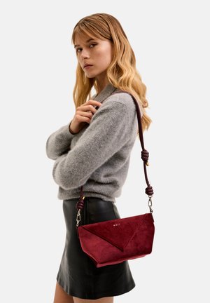 Czerwona torebka z zamszu o geometrycznym wzorze, z węzłowym paskiem i złotymi akcentami. Gładka tekstura z płaskim dnem.