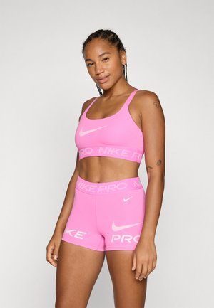 Rosa Sport-BH und Shorts-Set aus dehnbarem Stoff, mit einem breiten elastischen Bündchen mit "NIKE PRO"-Markierung. Akzentuiert mit einem weißen Logo.