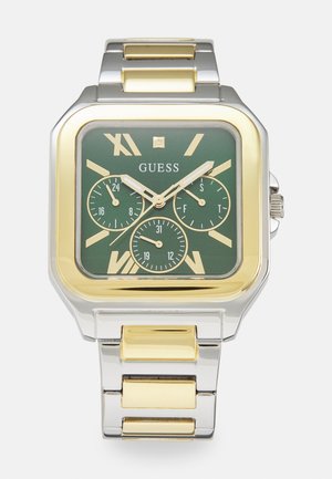 Montre carrée avec un cadran vert, des accents en or et en argent, trois sous-cadrans et des marqueurs en chiffres romains. Design de bracelet à maillons en métal.