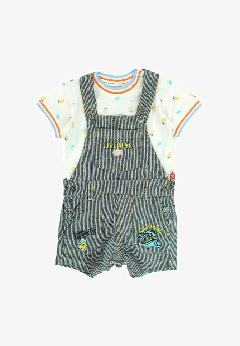 Salopette en denim rayé avec des broderies colorées et un t-shirt blanc à manches courtes comportant des motifs ludiques et des accents orange-bleu.