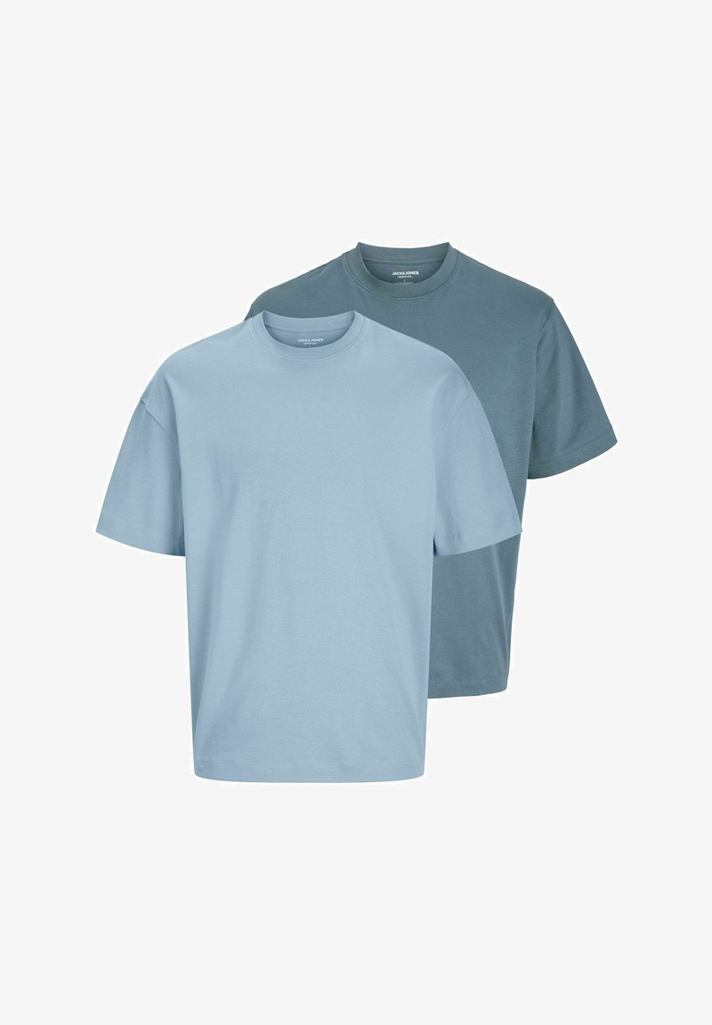 Dvoje tričiek s kruhovým výstrihom vyrobených z bavlny. Jedno je svetlomodré, druhé v tmavšej modrej farbe. Obe majú krátke rukávy a voľný strih.