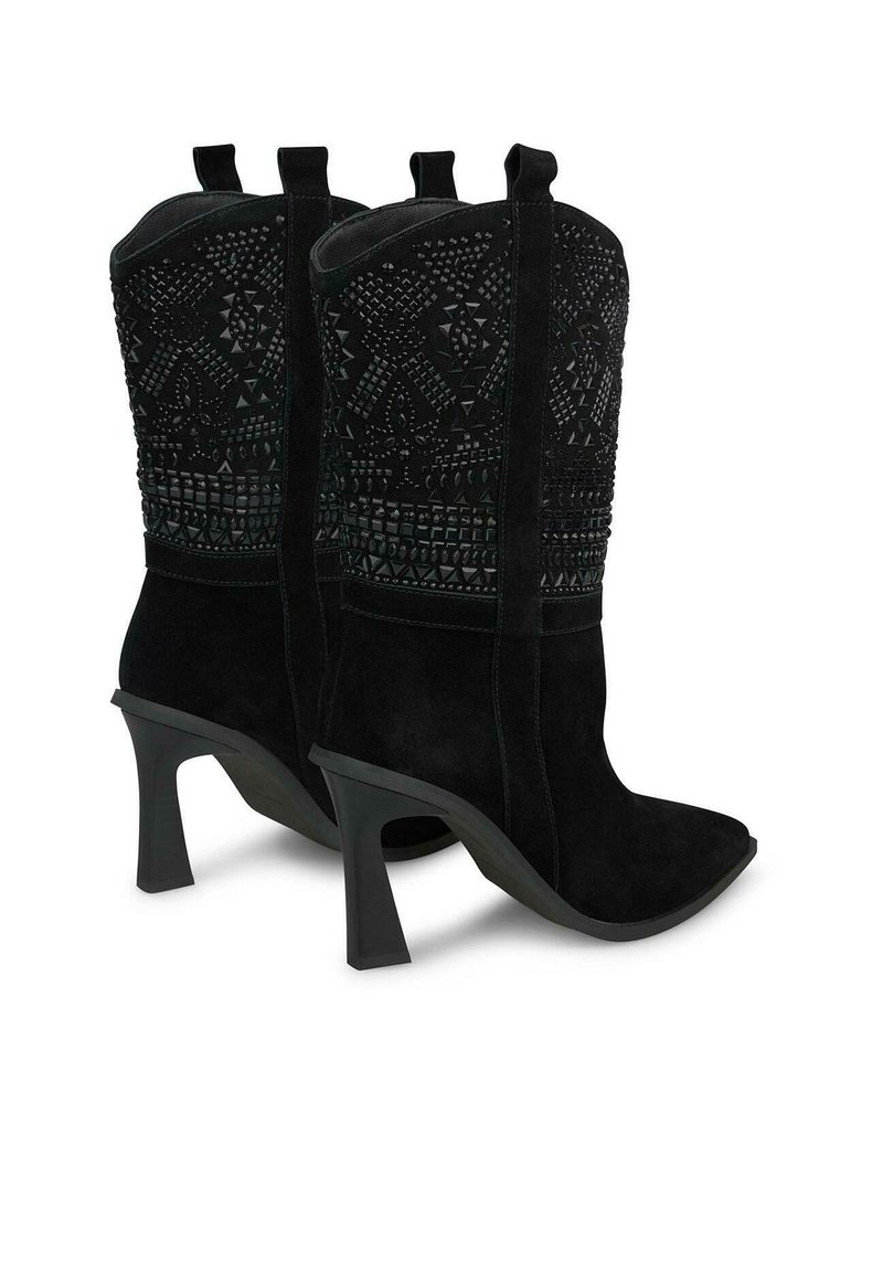 Botas de tobillo de ante negro con punta afilada y tacón alto. La parte superior presenta intrincados patrones en relieve y dos tiradores para facilitar su uso.
