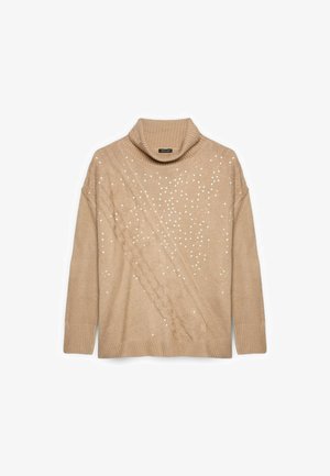Maglione beige a collo alto con design a treccia testurizzata e dettagli bianchi sparsi. Caratterizzato da bordi a coste e una vestibilità rilassata.