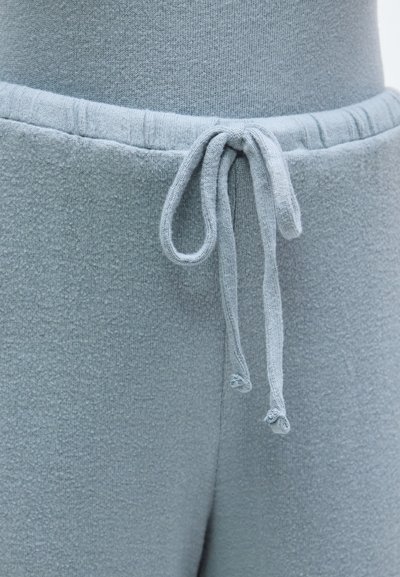 Puha, világoskék futónadrág texturált anyaggal, rugalmas derékrésszel és zsinóros megkötővel. Belső oldala sima bélésű.