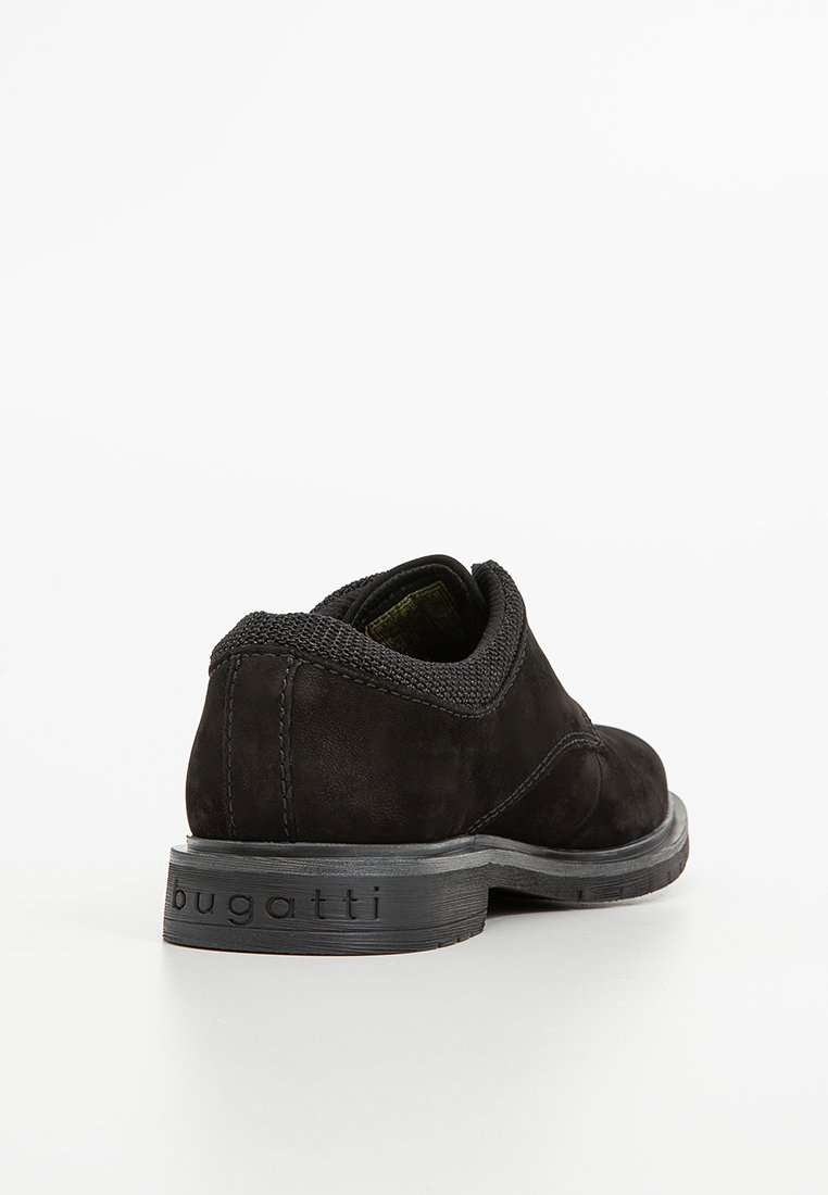 Zapato de ante negro con un collar de malla texturizada, puntera redonda y suela de goma que presenta la marca "bugatti" grabada en el lateral.