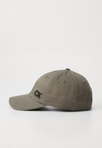 Olijfgroene baseballpet van katoen met een gebogen klep en geborduurd "CK"-logo aan de voorkant. Voorzien van ventilatie-oogjes.