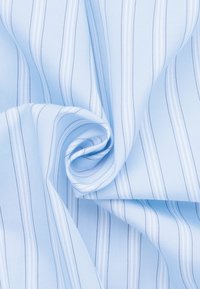 Hellblauer Stoff mit feinen weißen Streifen, glatte Textur, in weichen Falten drapiert, zeigt seine leichte und flexible Beschaffenheit.