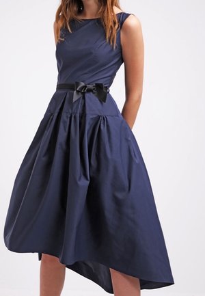 Granatowa sukienka bez rękawów, sięgająca do kolan, z dopasowanym gorsetem, marszczonym dołem i czarnym satynowym paskiem z kokardą w talii.