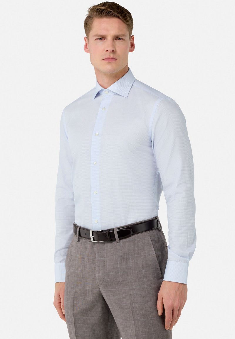 Light blue, textured dress shirt with long sleeves, button placket, and a classic collar, worn with gray, checkered dress pants and a black belt.