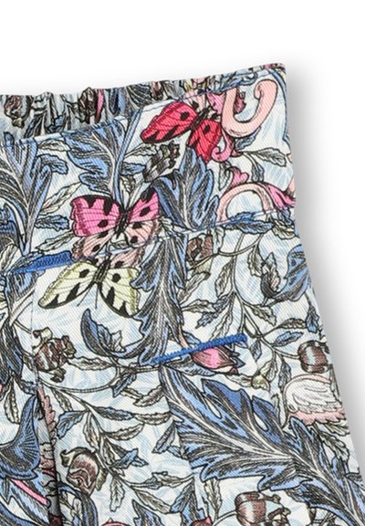 Tissu à imprimé floral présentant des papillons roses et verts sur un fond bleu clair. Taille smockée avec des détails en texture douce.