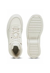 White leather sneakers with a textured surface, flat laces, and thick rubber sole, featuring a logo on the heel and patterned traction.