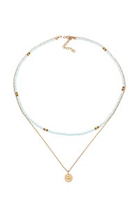 Guldtonet lagdelt halskæde med små blå perler indimellem guld accenter, der ender i en rund charm med et solmotiv.