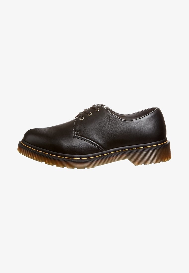 Chaussure Oxford basse en cuir noir avec trois œillets, couture jaune et semelle en caoutchouc marron translucide et épaisse.