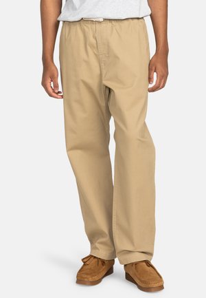 Beige, lightweight cotton pants with an elastic waistband, relaxed fit, and straight leg design, complemented by stitching details.