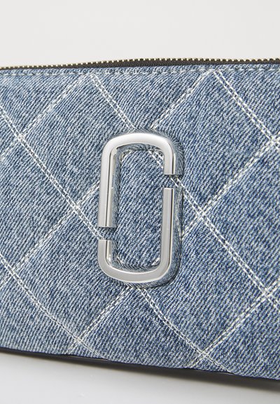 Clutch de denims acolchoado com hardware retangular prateado e padrão de costura branca. Fecho com zíper e superfície texturizada e durável.