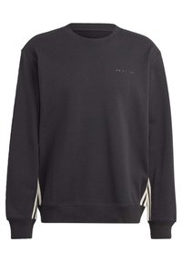 Svart långärmad sweatshirt med rundad hals, liten Adidas-logotyp och fyra prickar på bröstet, med vita sidoflikar nära fållen.