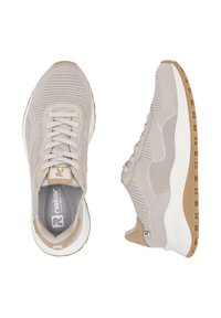 Baskets de sport beige avec une tige en mesh texturé, lacets et semelle intermédiaire blanche rembourrée. La semelle présente un motif en caoutchouc brun pour une meilleure adhérence.