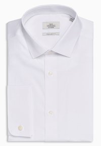 Chemise en coton blanche, coupe régulière, avec un col classique, des manches longues à poignets boutonnés et une poche poitrine unique.