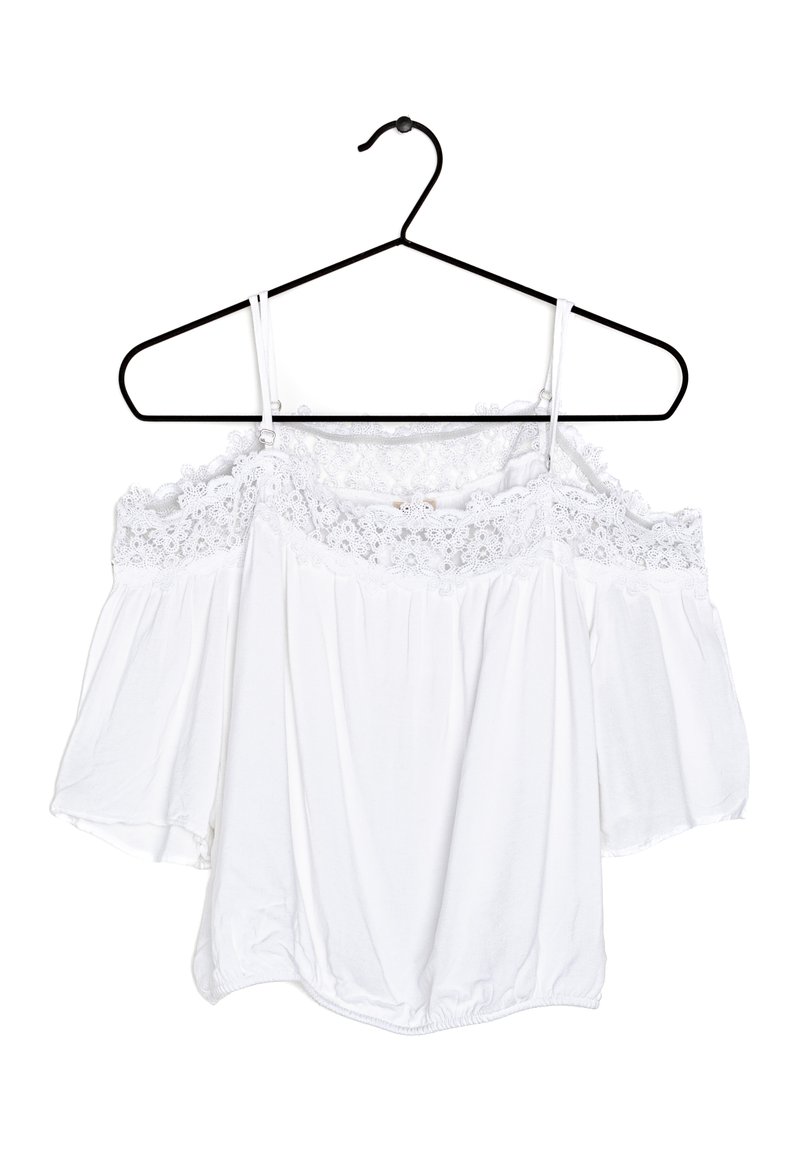 White off-the-shoulder blouse with lace detailing at the neckline, short billowy sleeves, and an elastic hem. Hangs on a black hanger.