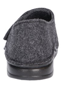 Grijze gevoerde slipper met een vlakke, stevige zwarte rubberen zool. Heeft een ronde achterkant en een eenvoudig, strakker ontwerp zonder versieringen.