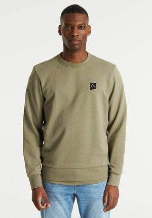 Olive green sweatshirt made of textured fabric, featuring a crew neck and long sleeves, with a black logo patch on the left chest.