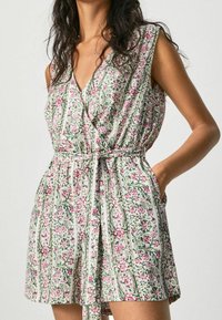 Šaty s květinovým vzorem a zavinovacím designem, s růžovými a zelenými akcenty, krátkými rukávy a zavazovacím páskem v pase. Měkká textilie.