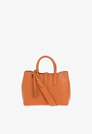 Sac à main en cuir cognac avec poignées roulées, bandoulière ajustable, détail pompon et couture simple sur fond blanc.