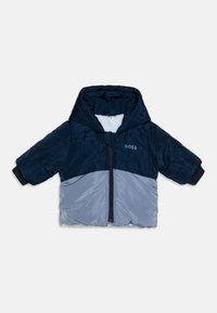 Casaco acolchoado em azul marinho e cinza claro com fecho zip na frente, mangas curtas e capuz. Apresenta logótipo no peito e punhos elásticos.