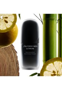 Shiseido Men Ultimune Power Infusing Serum i en elegant svart flaske, omgitt av skiver av sitron, bambusstilker og treverk.