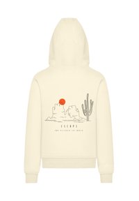 Cream-colored hoodie with a hood, featuring a graphic of mountains, a sun, and a cactus. The design includes the text "ESCAPE AND DISCOVER THE WORLD."