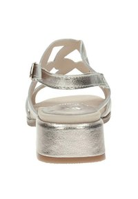 Sandalias metálicas de color plata con tiras, con un bajo tacón bloque. Presentan un diseño recortado en las tiras y una superficie superior lisa y texturizada.
