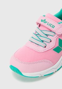 Ροζ αθλητικό παπούτσι με επάνω μέρος από δίχτυ, τυρκουάζ λεπτομέρειες, λουρί με αυτοκόλλητο και γκρι κορδόνια, με λευκή ενδιάμεση σόλα και υφή στην εξωτερική σόλα.