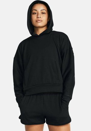 Felpa nera a coste con tasca a marsupio, abbinata a pantaloni corti coordinati. Il tessuto ha una texture morbida, con una vestibilità comoda e cappuccio.