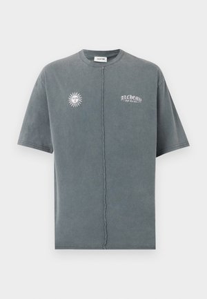 vervaagde grijze korte mouw T-shirt met centrale naad, zongezicht grafiek op de linkerborst en de tekst "ALCHEMY of the soul" op de rechterborst.