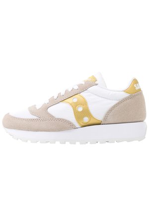 Fehér hálós és bézs velúr panelekből készült sneaker, arany kiegészítőkkel, kerek fémszerelvényekkel, textúrált gumitalppal és párnázott bokarésszel.