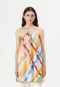 Haut halter coloré avec un mélange de rayures et de motifs géométriques dans des tons de rouge, orange, vert et bleu sur un fond clair.